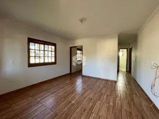 Sala de estar com piso de madeira e janela de madeira.