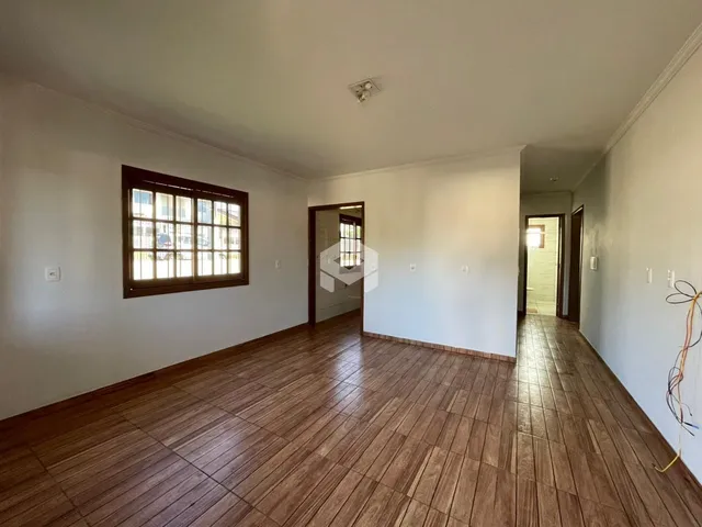 Sala de estar com piso de madeira e janela de madeira.
