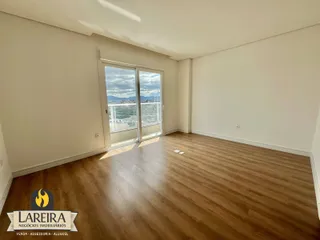 Ambiente interno com piso de madeira e porta de vidro com vista para a paisagem.