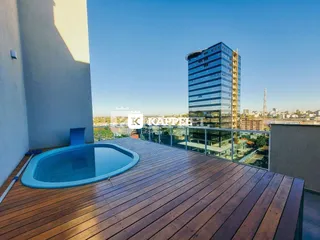 Varanda com deck de madeira e piscina em um apartamento em Lajeado.