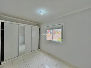 Vista interna de um corredor com piso de cerâmica branca.
