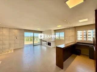 Sala ampla com piso de cerâmica e vista para o exterior.