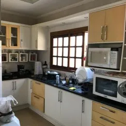 Cozinha com armários e bancadas escuras em um imóvel.