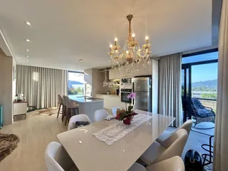 Vista de uma sala de jantar e cozinha moderna em um imóvel no Brasil.