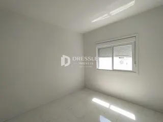 Ambiente interno de uma sala com piso de mármore e janela.