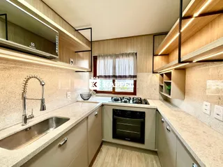 Cozinha moderna com armários de madeira e bancadas claras.