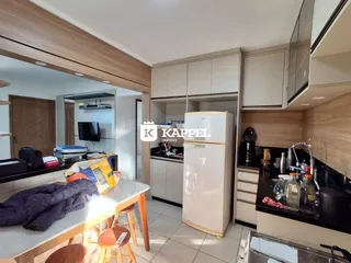 Esta é uma foto da cozinha com armários brancos e bancadas escuras.