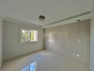 Vista interna de uma sala com paredes brancas e piso claro.