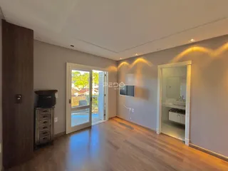 Sala de estar com piso de madeira e porta de vidro abrindo para o exterior.