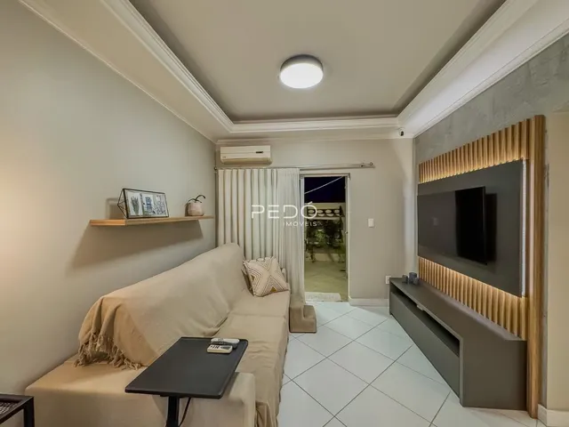 Sala de estar com sofá e painel de TV em um apartamento.