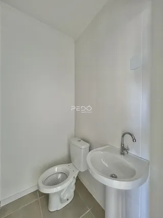 A foto mostra o interior de um banheiro com azulejos brancos.