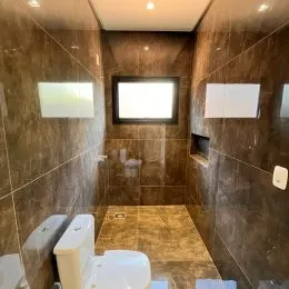 Foto de um banheiro com paredes revestidas de azulejos.