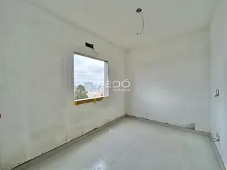 Foto de um cômodo vazio com uma janela que oferece uma vista da paisagem urbana.
