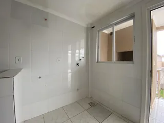 Foto de um cômodo interno com paredes brancas e piso de cerâmica.