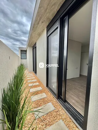 Vista da fachada de uma residência em Lajeado, mostrando um caminho de pedras e vegetação.