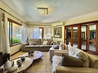 Sala de estar com sofá e janelas em uma residência no Brasil.