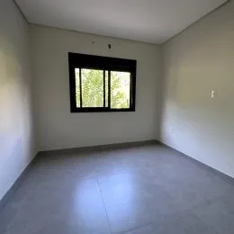 Foto de um cômodo interno com paredes brancas e uma janela.