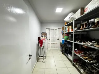 Hall de entrada com paredes brancas e piso de cerâmica.