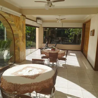 Uma sala de jantar com mesas de vime e cadeiras em um apartamento em Lajeado.