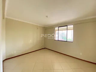 Vista interna de uma sala com piso de cerâmica e paredes claras.