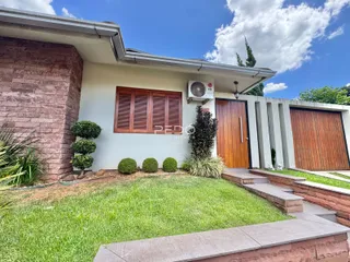 Fachada de uma residência em Lajeado, Brasil, com jardim frontal e garagem.