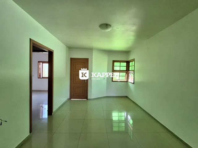 Hall de entrada com paredes brancas e piso de cerâmica claro.