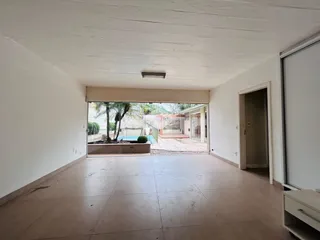 Vista interna de um ambiente com acesso a uma área externa através de portas de vidro.