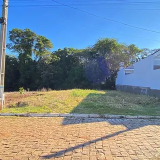 Foto da fachada de uma propriedade com gramado e árvores ao fundo.