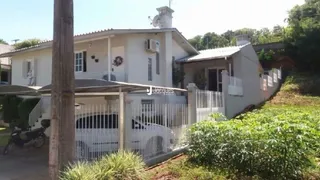 Fachada de uma residência em Lajeado, Brasil, com cerca e portão brancos.