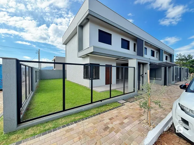 Fachada de uma casa moderna em Lajeado, Brasil, com quintal gramado e cerca.