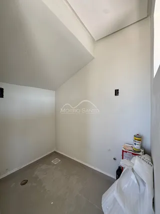 Ambiente interno com paredes brancas e piso claro.
