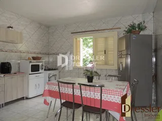 Interior de uma cozinha com revestimento de azulejo branco e móveis de cozinha.