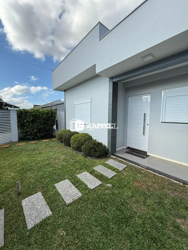 Fachada externa de uma casa moderna com jardim em Lajeado, Brasil.