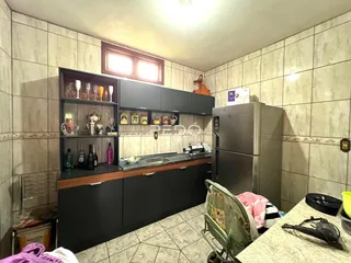 Cozinha com armários escuros e piso de cerâmica.