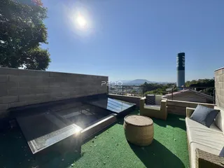Vista de uma área externa com mobiliário e vista panorâmica.