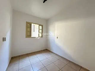 Ambiente interno de uma sala com piso de cerâmica clara e janela.
