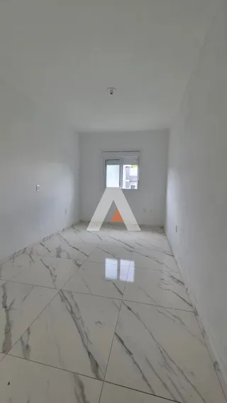 Hall de entrada com piso de mármore claro e paredes brancas.