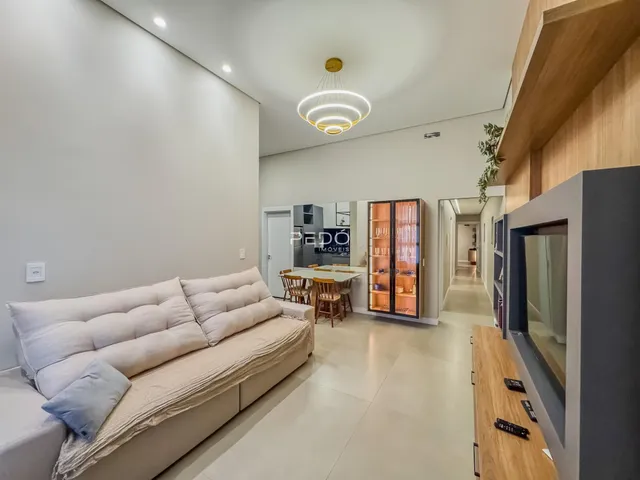 Sala de estar moderna com sofá e piso claro em um imóvel no Brasil.