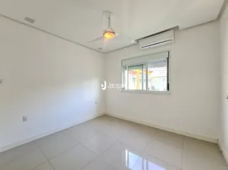 Ambiente interno de uma sala com piso de cerâmica e ar-condicionado instalado.