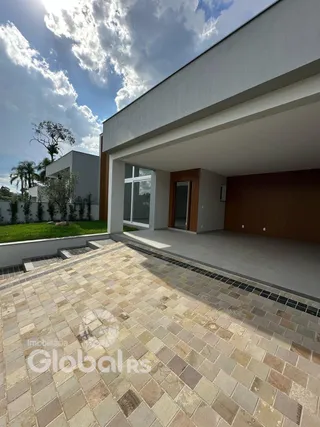 A fachada de uma residência moderna com área externa pavimentada.