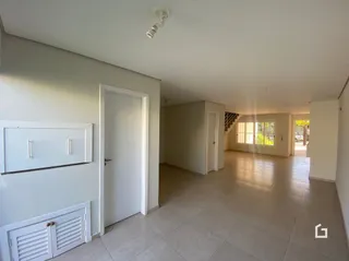 Hall de entrada com piso de cerâmica e porta branca.