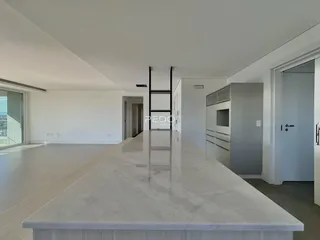 Vista de uma cozinha com bancada de mármore claro em um imóvel.