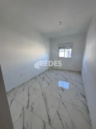 Ambiente interno de uma sala com piso de mármore claro.