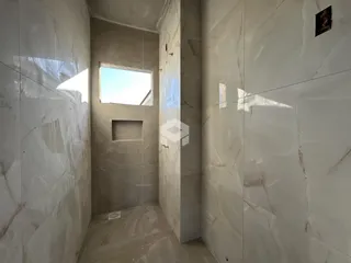 Corredor interno com revestimento em mármore branco nas paredes.