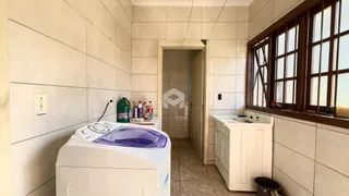 Interior de uma área com máquina de lavar roupa e janela em um imóvel.
