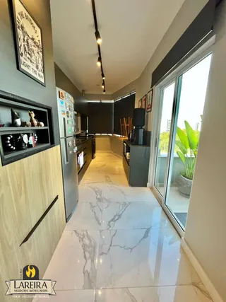 Sala de estar com piso de mármore claro e grandes janelas.