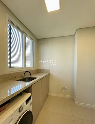 Vista interna de uma cozinha com bancadas e janela em um imóvel.