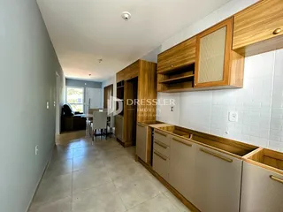 Vista de um corredor interno com armários de madeira e piso cerâmico.