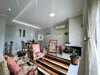 Sala de estar com decoração de estofados e piso de madeira.