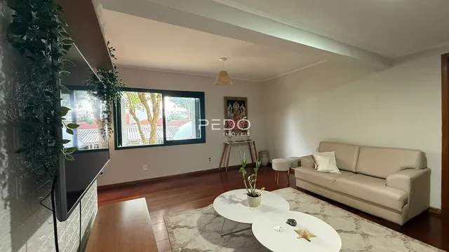 Sala de estar com piso de madeira e vista para o exterior.